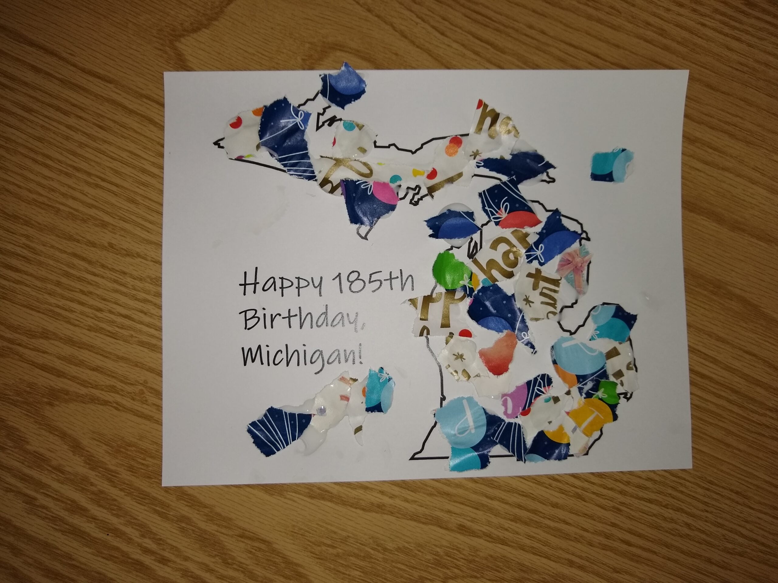 185th Birthday card for Michigan with scraps of Birthday Wrapping paper blued to the outline of Michigan.